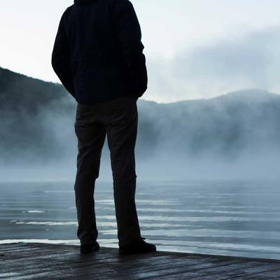 英雄联盟职业选手Scout面带微笑接受专访, 身穿EDG队服, 背景是比赛场馆